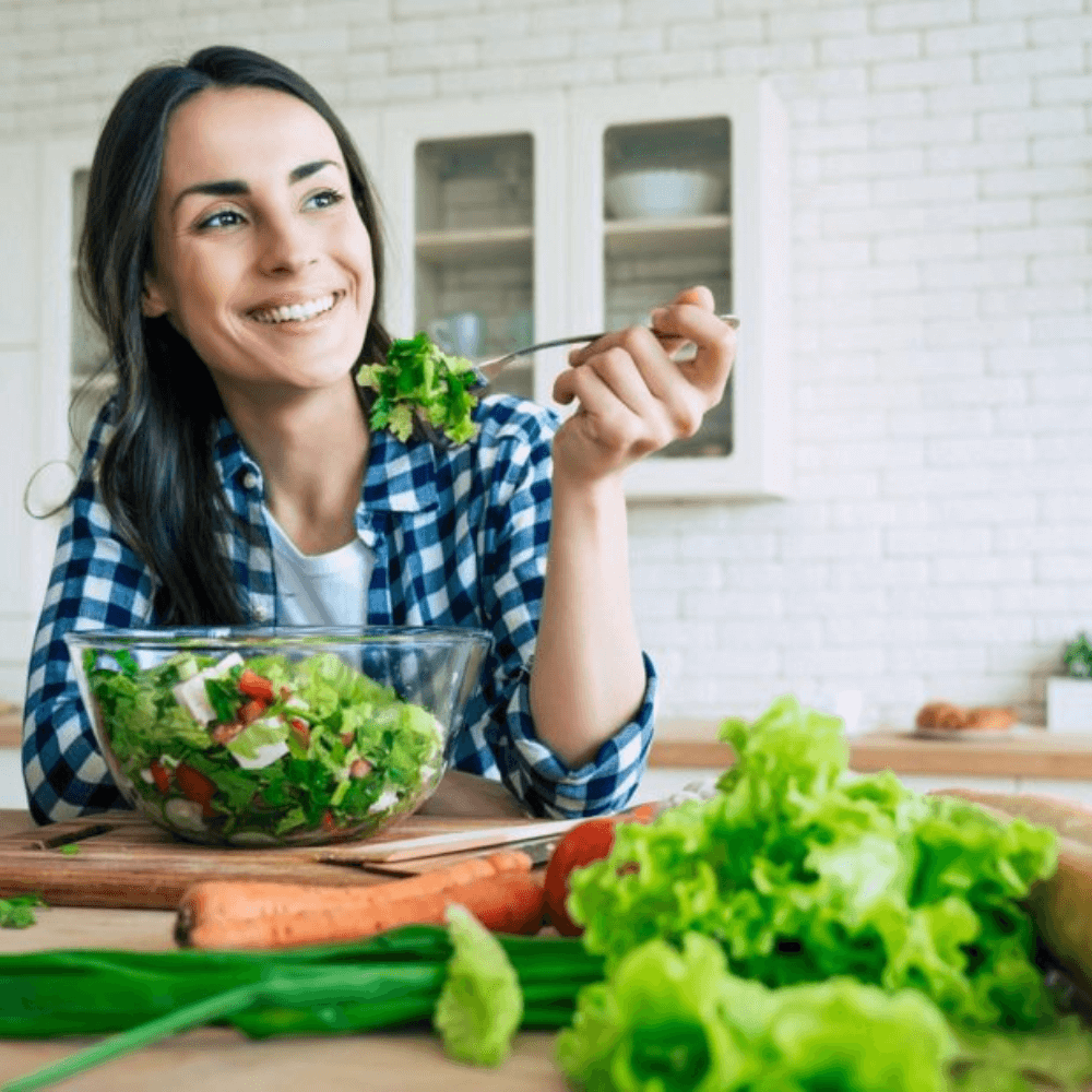 A smiling girl is sitting and eating food