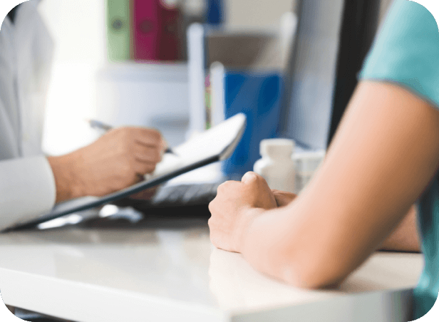 Close-up view of a medical consultation taking place at a desk