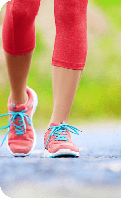 Close-up view of a runner's legs and feet mid-stride on a paved surface