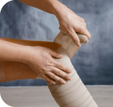 A woman is wrapping a bandage around her foot