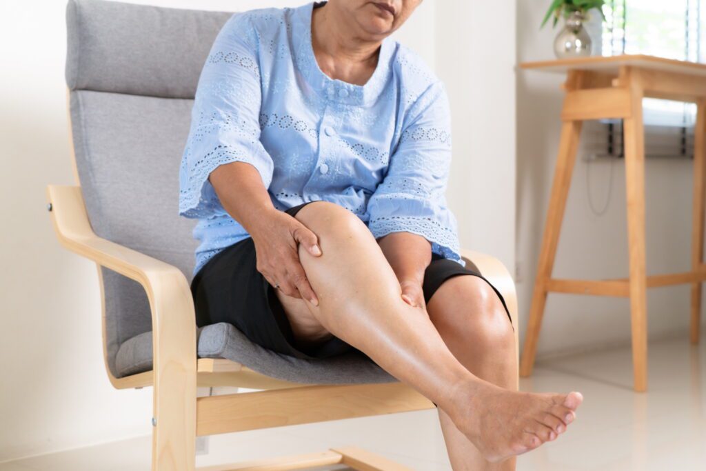 senior woman suffering from knee pain at home, health problem concept