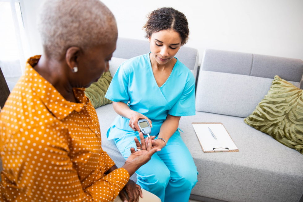 A female doctor is checking the blood of an elderly woman.