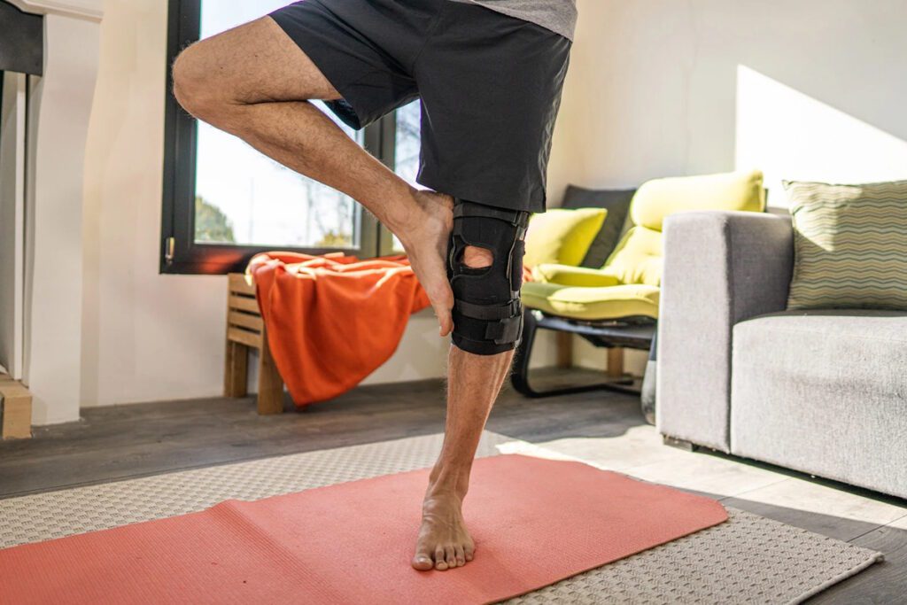 A man wearing a knee brace fixator to support his knee osteoarthritis.