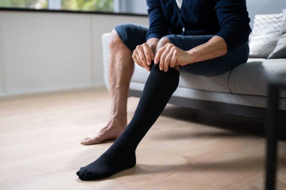 A pair of knee-high compression stockings laying flat on a white background.