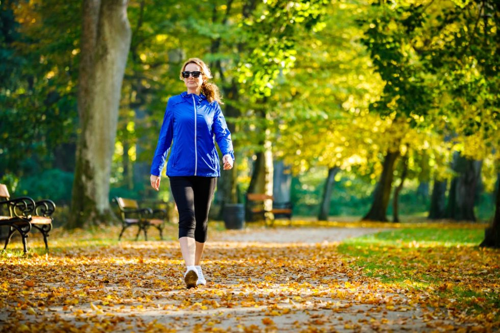 Mid aged woman running in city park