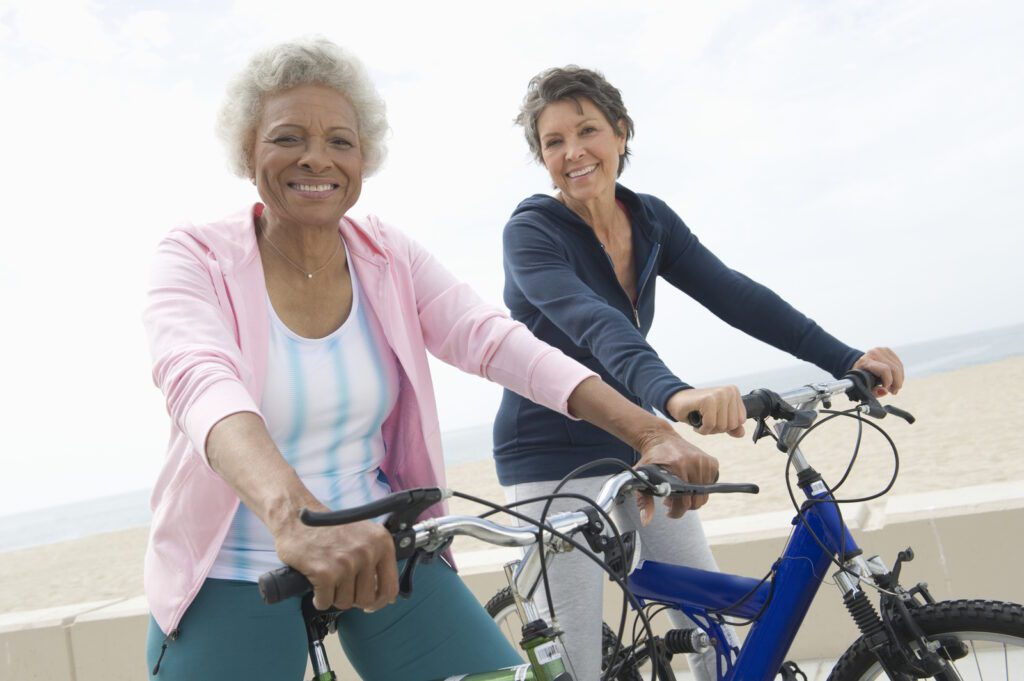 Portrait of happy senior multiethnic female friends riding bicycles together