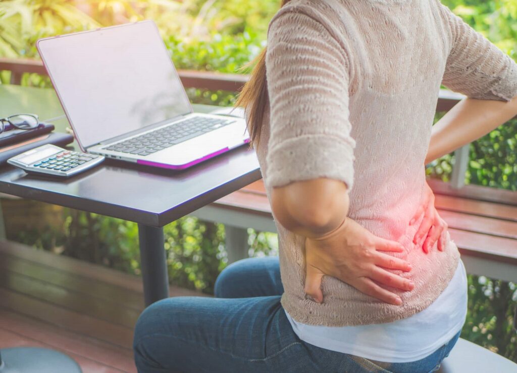 Young girls with pelvic pain have their hand on their lower back.