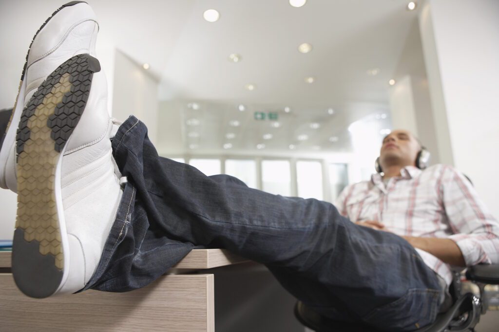 A young man is resting with his legs up on the table.