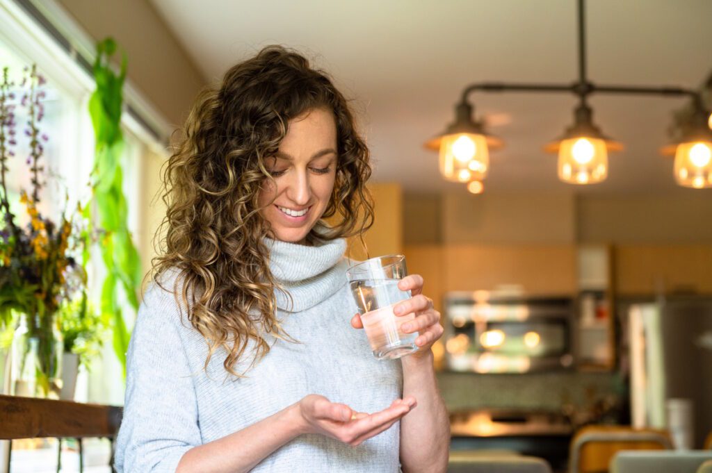 Woman taking a vitamin. Women, healthcare and wellbeing concepts.