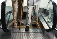 the lower half of a person standing on an escalator