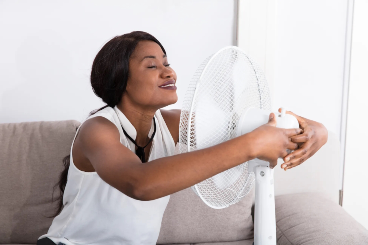 summer leg swelling woman using fan to stay cool