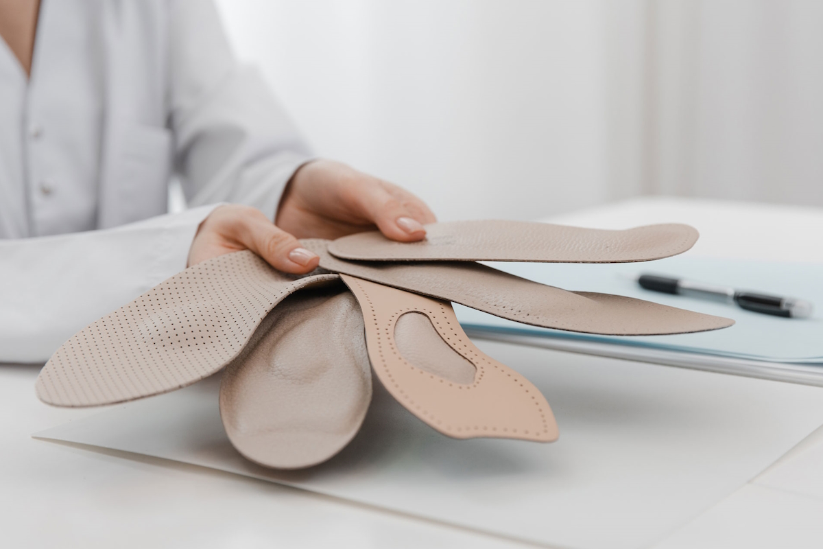 orthotic insoles doctor holding orthopedic insoles